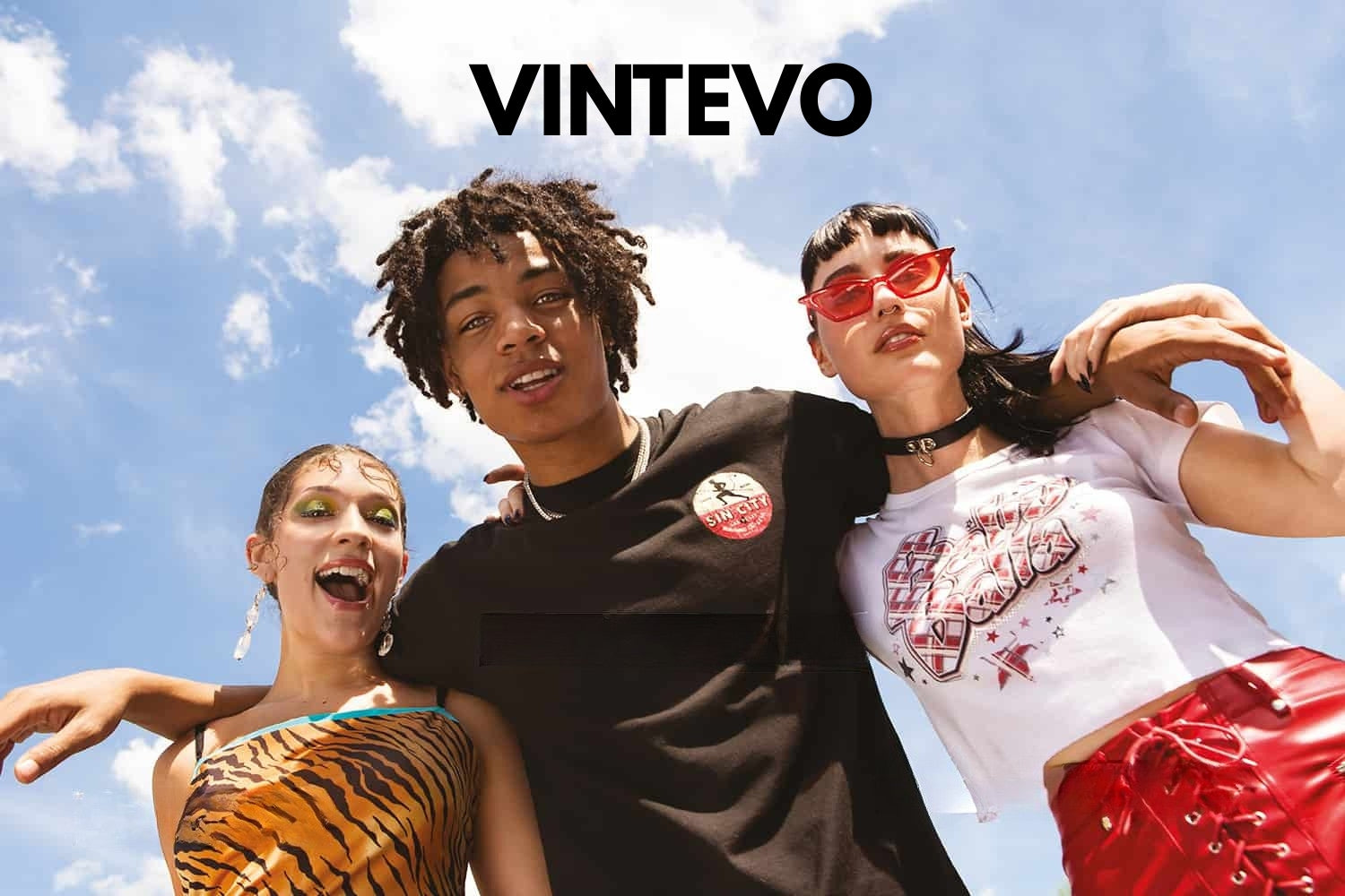 Three people posing outdoors with a clear blue sky, featuring the brand 'Vintevo'.